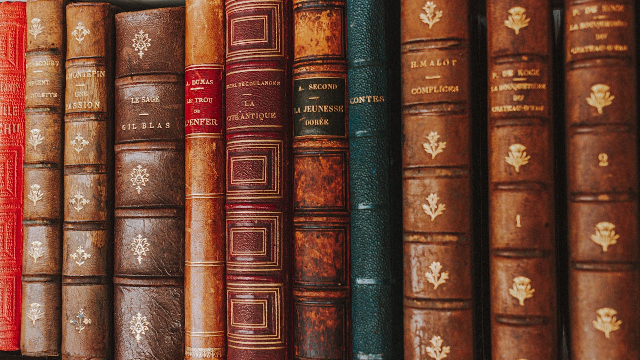 Close-up of vintage leather-bound books showcasing ornate spines.